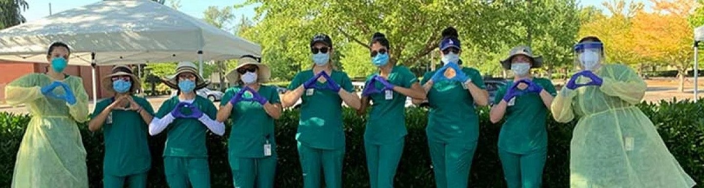 Group of people in ppe making O with hands