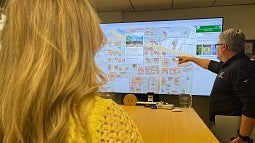 Person pointing to large map on a screen